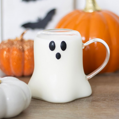 Clear glass Ghost-shaped mug with pumpkins and a white pumpkin in the background