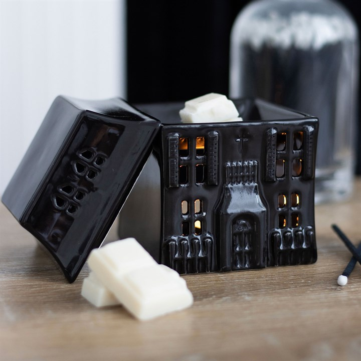 Black castle-shaped candles with white wax on a wooden surface