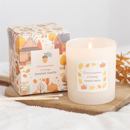 Cinnamon Woody scented candle with packaging on a wooden tray