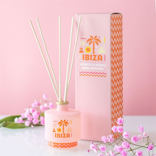 Reed diffuser with 'Ibiza' branding on a pink background