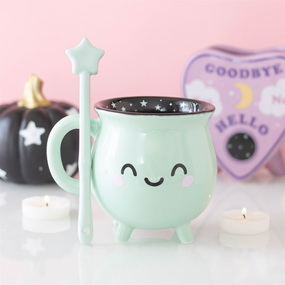 Mint green halloween mug with star design, spoon, and candles on a pink background