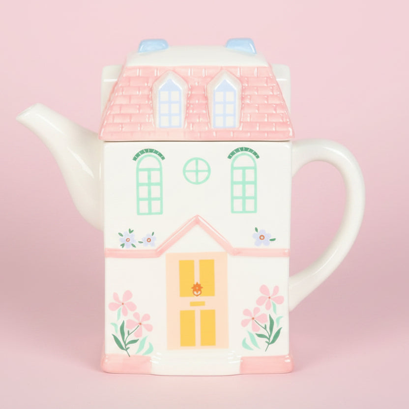 house shaped teapot on soft pink background